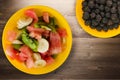 Plate of healthy fresh fruit salad on wooden background Royalty Free Stock Photo