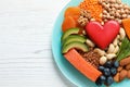 Plate with heart-healthy products on wooden background, top view. Royalty Free Stock Photo