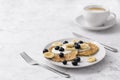 Plate of homemade breakfast with forest fruits and cup of coffee at marble table Royalty Free Stock Photo