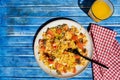 Plate with homemade chicken salad, carrot, tomato and brown rice on a rustic blue wooden table. Aereal view