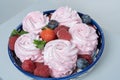 A plate with homemade marshmallows, decorated with berries. On a gray background. Bakery advertising concept, cooking secrets