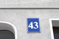 Plate with house number fourty three on light grey wall outdoors Royalty Free Stock Photo
