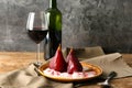 Plate with ice cream and sweet pears stewed in red wine on wooden table