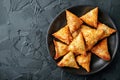 Plate with indian samosas on black stone background. Generative AI