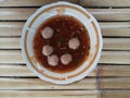 A Plate of Indonesian Meatball Soup or Bakso on Bamboo Surface