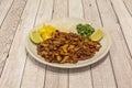 Plate of ingredients of tacos al pastor. Chopped pineapple, gisada meat, chopped onion and coriander with two pieces of lime on a Royalty Free Stock Photo