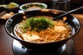 a plate of japanese ramen, with thick noodles in a flavorful broth