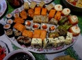 Plate with japanese sushi rolls on the table. Cloth with the Ukrainian ornament `vyshivanka`.