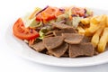 Plate of kebab, vegetables and french fries