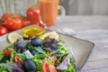 Plate with keto diet food. Chopped vegetables for the ketogenic diet on a plate. Tomatoes, salad with arugula, avocado and olives Royalty Free Stock Photo