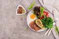 Plate with a keto diet food. Fried egg, bacon, avocado, arugula and strawberries. Royalty Free Stock Photo