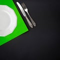 Plate, knife and fork on black background table flat lay Royalty Free Stock Photo