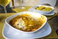 A plate of lasagna with a glass of white wine