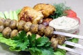 In a plate lies fried chicken thighs, mushrooms on skewers with vegetables Royalty Free Stock Photo