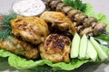 In a plate lies fried chicken thighs, mushrooms on skewers with vegetables Royalty Free Stock Photo