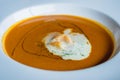 A plate of lobster bisque decorated with a dollop of cream and small shrimps