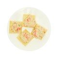 Plate of lobster dip on saltine crackers on white background