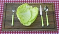 Plate made from cabbage and fork, knife and spoon beside