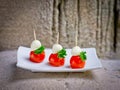 Plate of many mini bite size tomato and mozarella cheese sandwich appetizers Royalty Free Stock Photo