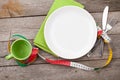 Plate with measure tape, cup, knife and fork. Diet food on woode Royalty Free Stock Photo