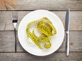 Plate with measure tape, knife and fork. Diet food Royalty Free Stock Photo