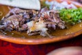 Plate of Mexican chopped lamb meat on colorful tablecloth