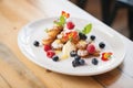 a plate of mini cannoli with berry garnishes