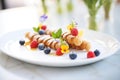 a plate of mini cannoli with berry garnishes