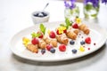 a plate of mini cannoli with berry garnishes