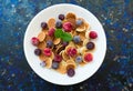 Plate with mini pancakes and berries on a dark blue background. Flat lay. Royalty Free Stock Photo