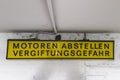 Plate: Motoren abstellen Vergiftungsgefahr . On a gray background