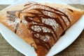 Plate of Mouthwatering French Crepe with Chocolate Sauce and Icing Sugar