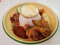 A plate of Nasi Lemak with crispy chicken wings Royalty Free Stock Photo