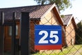 Plate with number twenty five hanging on fence near houses outdoors