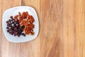 Plate with nuts and raisins on wooden table. copy space