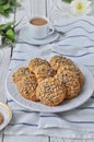 On a plate oatmeal cookies with seeds, white light wooden background
