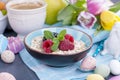 A plate of oatmeal with fresh raspberries and mint. Flavored coffee. A bouquet of spring tulips.