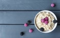 Plate of oatmeal porridge with berries on wooden grey background