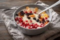 1 plate of oatmeal porridge with fruit slices, tangerine slices, raisins, dried apricots, pomegranate seeds on a gray napkin on a