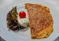 Plate with an omelet, goat cheese, lettuce and a cherry tomato, traditional Montenegro breakfast food, al fresco dining