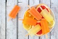 Plate of orange, lemon and grapefruit popsicles on rustic wood Royalty Free Stock Photo