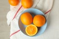 Plate with oranges and kitchen towel on white background Royalty Free Stock Photo