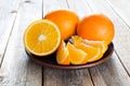 Plate with oranges on wooden table Royalty Free Stock Photo