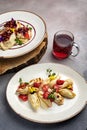 Plate of pancakes topped with strawberries, filled with a delicious filling, with a glass of tea Royalty Free Stock Photo