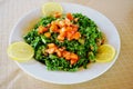 Plate of parsley and tomato tabbouleh with lemon wedges