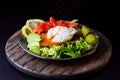 Plate with pashot eggs served on bread with salmon and vegetables