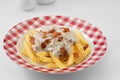 plate with pasta carbonara on white background.