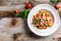 Plate of pasta penne with cherry tomato sauce, chicken meat and grated parmesan cheese. Pasta al Pomodoro on rustic wooden table. Royalty Free Stock Photo