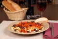 A plate of pasta puttanesca with wine and bread Royalty Free Stock Photo