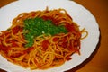 Plate with pasta, tomatosauce, basil and other herbs seafood